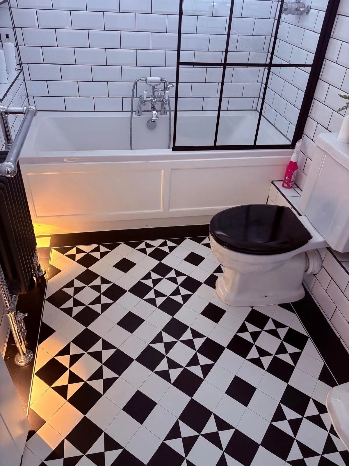 Sparkling black and white tiled bathroom floor after a deep clean
