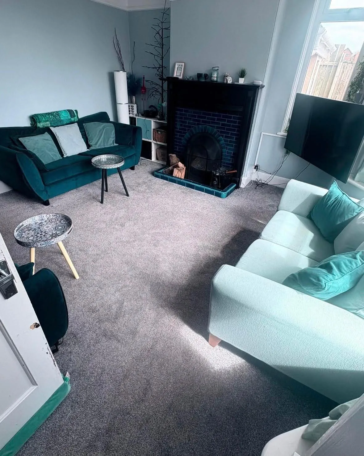 A tidy, freshly cleaned living room with teal sofas